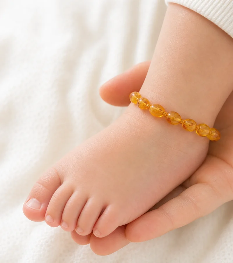 Pezinho de bebê com tornozeleira de âmbar