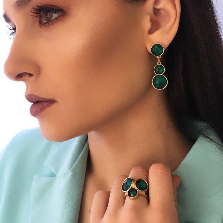 Anel Glamour Folheado a Ouro e Ródio Negro com Três Esmeraldas - modelo usando a linha